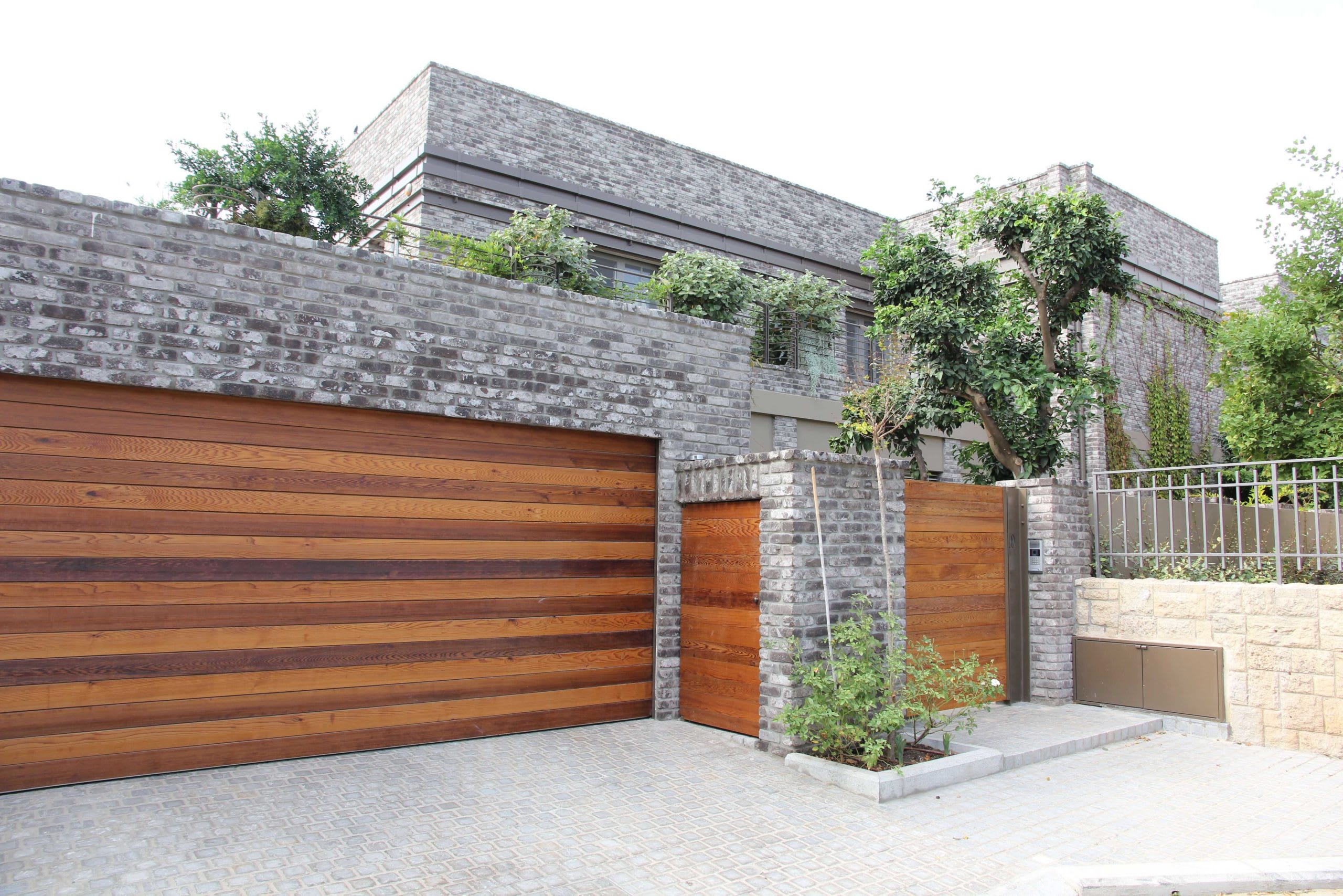 Grey brick exterior with a wooden garage door