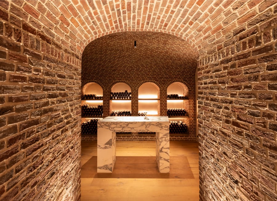 A wine cellar with brick walls and ceiling.