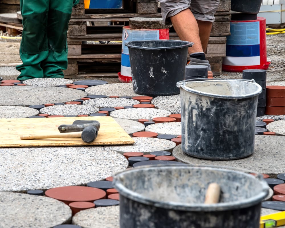 A worker finishes a concrete stone path.